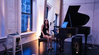 a woman sitting at a piano in a room